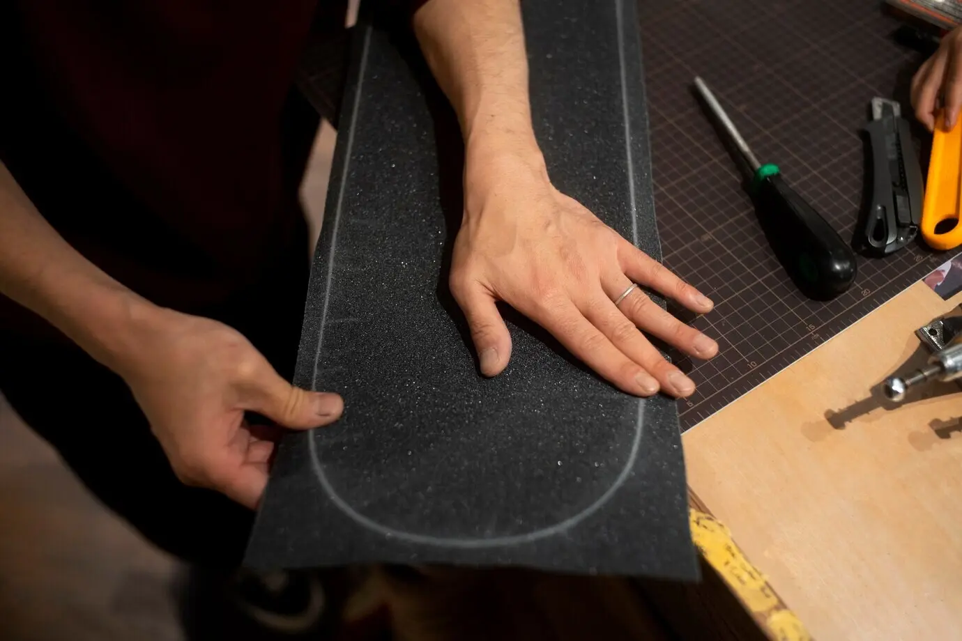 Hände, die Griptape halten.